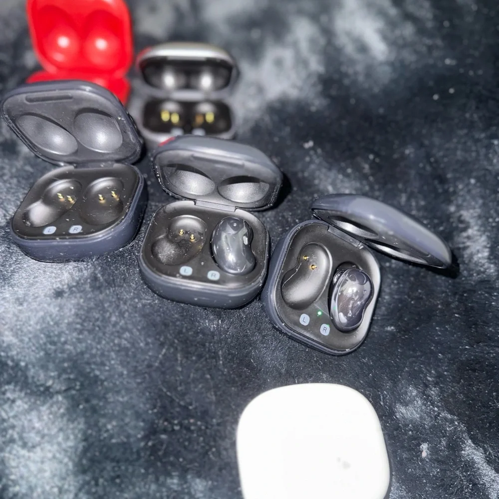 Samsung Earbud Charging Cases in Black, White, Red, and Silver with 2 earbuds.